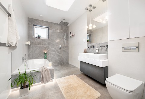Prostorná koupelna s velkou vanou, která je podsvícená a částečně zapuštěná do podlahy, a se sprchovým koutem (190x150 cm)